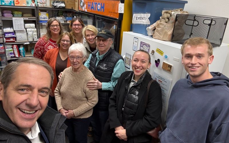 Group of people smiles for a selfie inside the Hatch Food Pantry.