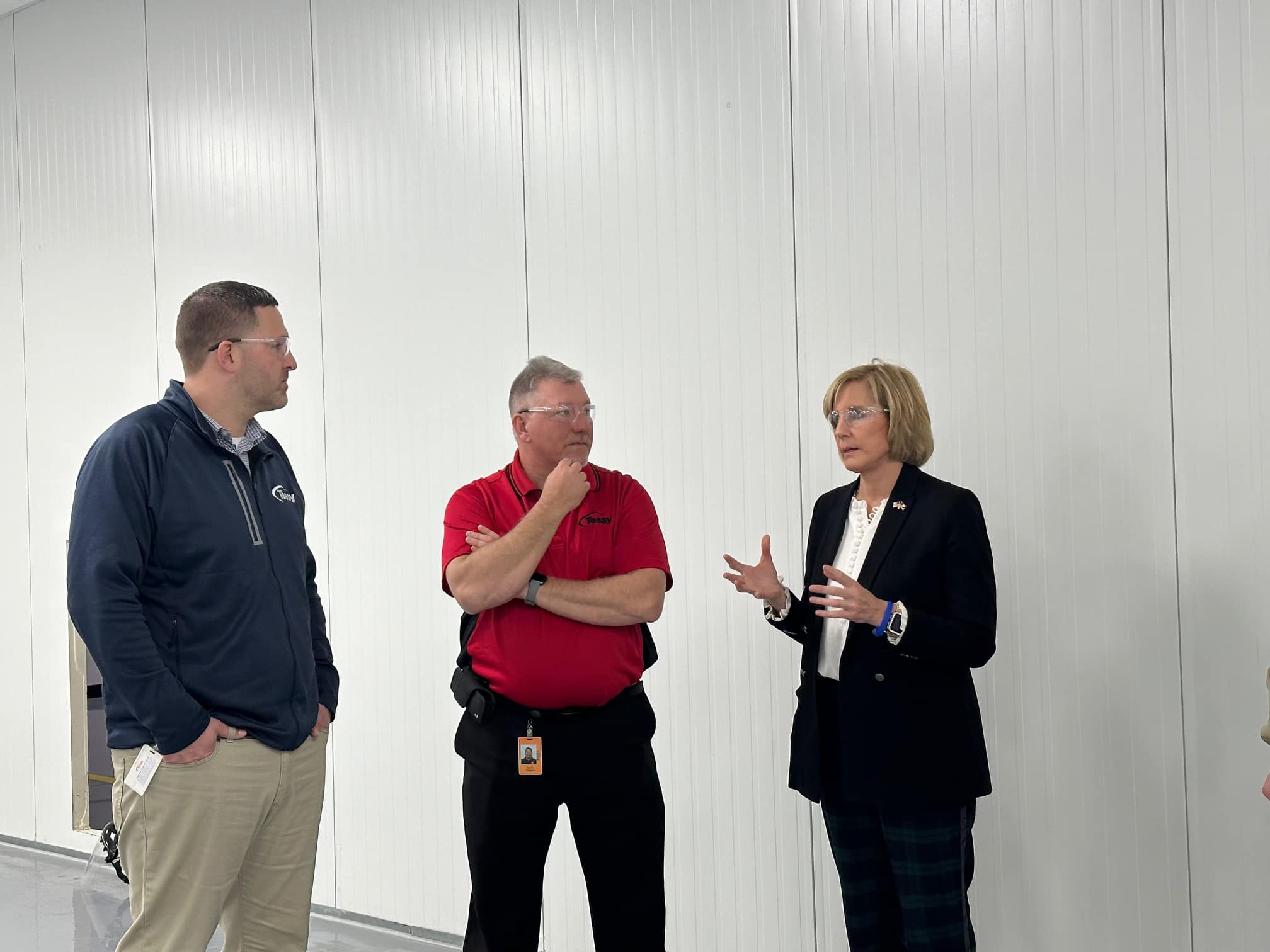 Congresswoman Claudia Tenney speaks with two men at Tessy Plastics during a business visit.