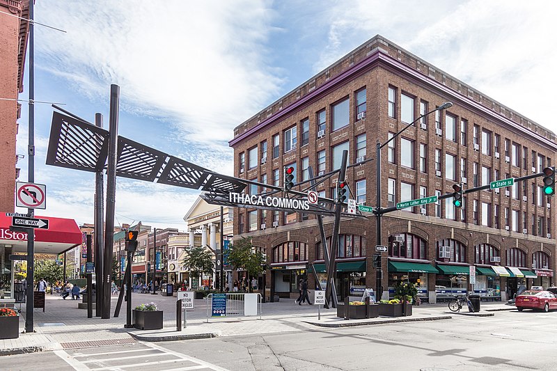 Street view of the Ithaca Commons sign and pedestrian area at State and Cayuga Streets in Ithaca, New York.