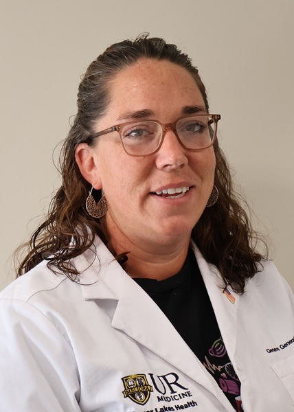 Theresa Fletcher, RN, in a lab coat with the UR Medicine Finger Lakes Health logo, smiling.