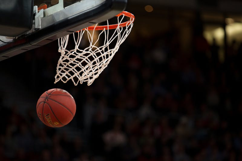 A Spalding basketball descends through a hoop during a game.