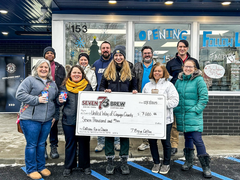 Group from 7 Brew Auburn presents a $7,000 check to United Way of Cayuga County outside the coffee shop.