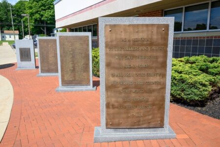 Bronze plaques on stone monuments honoring veterans outside Penn Yan Hospital.