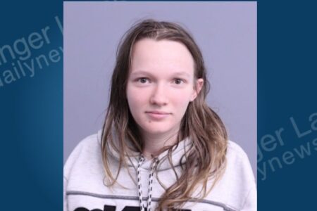 Mugshot of Alexus Barts, a woman with long brown hair, wearing a grey hoodie, facing forward.