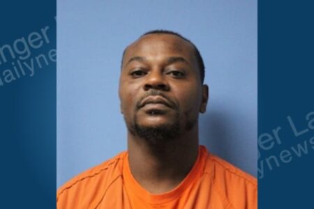 Mugshot of Antonio Poole, a man with a beard, wearing an orange shirt against a blue background.
