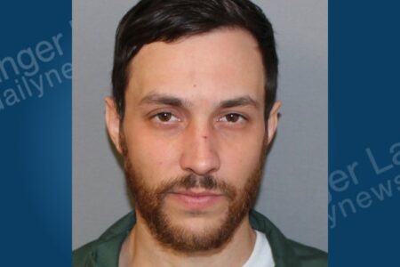 Mugshot of Cody Cooper, a man with dark hair and beard, charged with petit larceny.