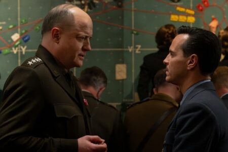 Brendan Fraser as a general and Andrew Scott in a suit discuss strategy in a WWII war room.