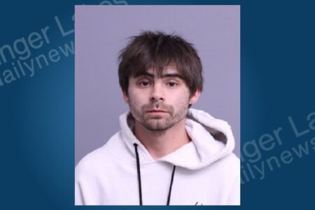 Mugshot of Evan Robson, a man with brown hair and a beard, wearing a white hoodie, against a grey background.