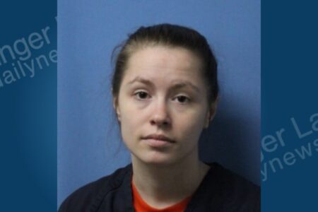 Mugshot of Holly Craner, a woman with dark hair pulled back, looking directly at the camera.