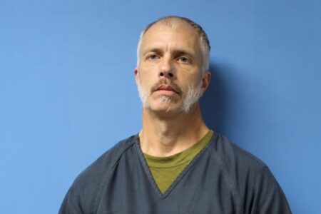 Mugshot of Jason Edwards, a Wolcott man charged in a child sex abuse investigation, against a blue background.