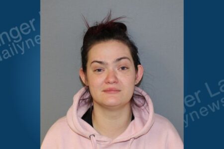 Mugshot of Jocelyn Nichols, a woman with dark hair in a bun, wearing a pink hoodie, charged with child abuse.