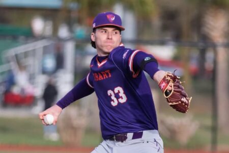 Hobart baseball player Joe Dunham, wearing a purple uniform with number 33, pitches during a game.