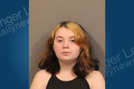 Mugshot of Lillian Edgington, a young woman with dark and blonde hair, accused of stealing from a store.