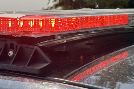 Close-up of flashing red emergency lights on top of a police vehicle.