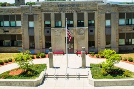 Exterior view of Odessa-Montour Central School building with an American flag flying in front.