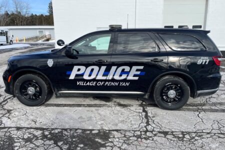 Black Penn Yan Police SUV with 'POLICE VILLAGE OF PENN YAN' on its side, parked on an asphalt lot.