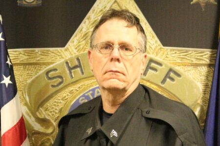 Roger Ward, a Seneca County Sheriff's officer, in uniform with a sheriff's badge and American flag.