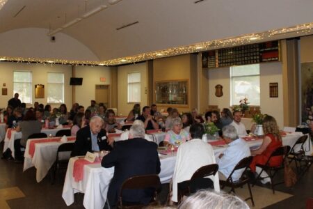 Attendees at the Bath event honoring Steuben County foster parents, seated at tables in a decorated hall.