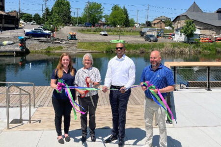 Four people cut a ribbon at Walkerbilt Park in Penn Yan, celebrating its completion.