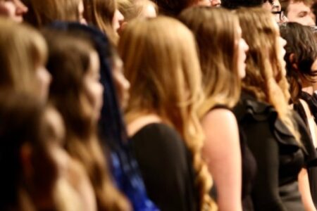 Victor High Chorus members stand in profile, likely performing at a concert.