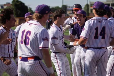 Hobart baseball players in pinstriped uniforms celebrate a victory on the field, one player yelling excitedly.