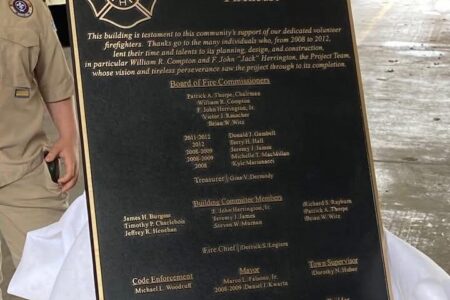 Bronze plaque honoring East Bloomfield Fire District Firehouse builders, listing names and roles from 2008-2012.