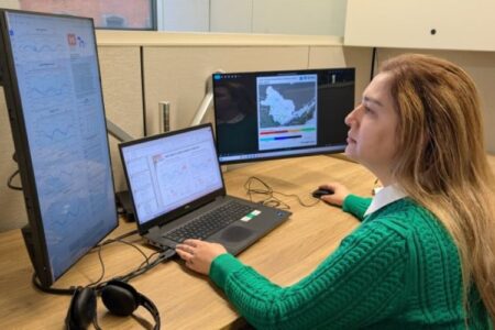 A woman monitors data on multiple screens, tracking spring flood risks for Lake Ontario.