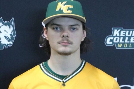 Keuka College baseball player Evan Cuba in his green and yellow uniform and cap, looking at the camera.