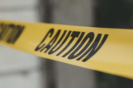 Yellow caution tape with the word 'CAUTION' in black letters, signifying a restricted or dangerous area.