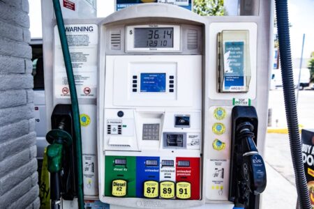 A close-up of a gas pump displaying fuel prices and different octane options.