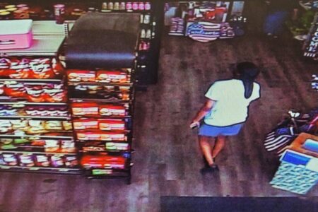 Overhead security camera view of a person in a store, identified as a wallet theft suspect.