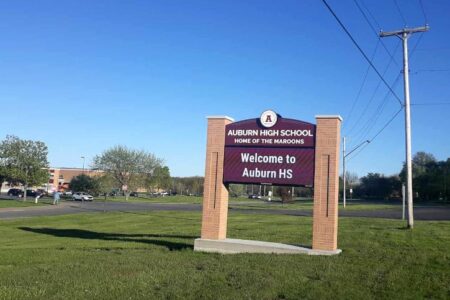 Entrance sign for Auburn High School, Home of the Maroons, with the school building in the background.