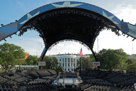 A large outdoor arena with empty seats and a stage, set up in front of the White House for a UFC event.