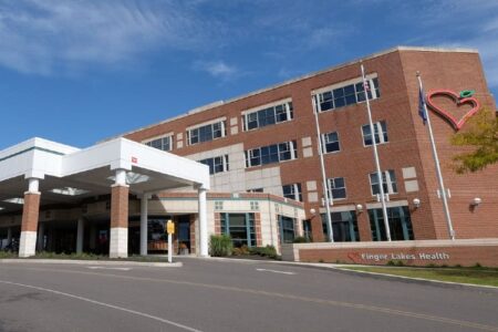 Exterior view of Geneva General Hospital, a brick building with a white entrance and Finger Lakes Health logo.