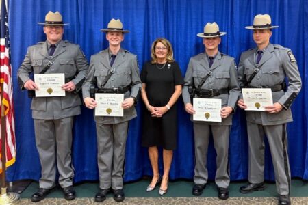 Senator Pam Helming with four new New York State Troopers holding graduation certificates.