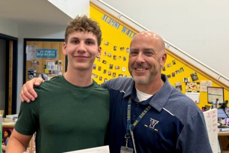 Victor senior Hudson Pender and Mr. Siesto smile after Pender received a scholarship for Camp Smile service.