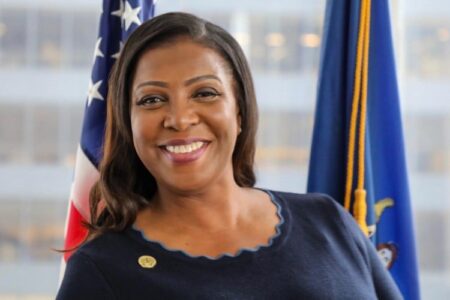 New York Attorney General Letitia James smiling in front of an American flag.