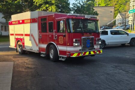 A red Middlesex Hose Company fire truck with 'RESCUE 8' on its side drives on a street.