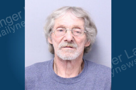 Mugshot of Milford Therrian, an older man with gray hair, glasses, and a beard, arrested for welfare fraud.