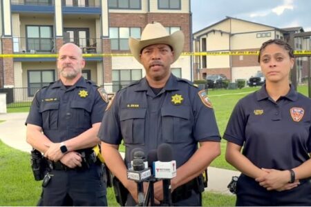 Law enforcement officers hold a press conference at the scene of a murder-suicide and SWAT standoff.