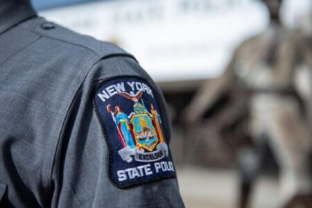 Close-up of a New York State Police patch on a grey uniform sleeve.