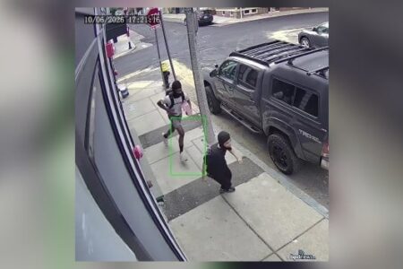 Surveillance image of two suspects on a Boston sidewalk, one running, one crouching, after a robbery.
