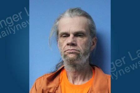 Mugshot of Robert Clingerman, a man with gray hair and beard, wearing an orange shirt, arrested on drug charges.