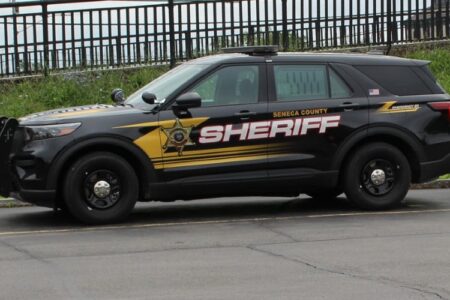 A black Seneca County Sheriff's SUV with yellow and white decals, parked outdoors.