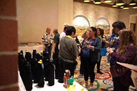 Attendees at the United Way of Seneca County's 'Taste of Spring' fundraiser, with bottles and decor.