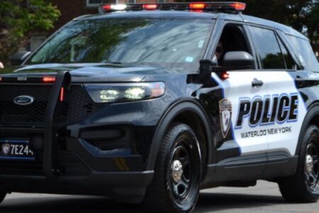 A black and white Waterloo New York Police Department SUV with emergency lights on.
